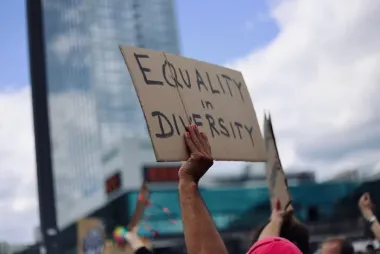 A hand holding a poster that says Equality in Diversity