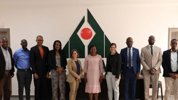 Group of diverse people posing for photo in front of CESAG logo on wall.